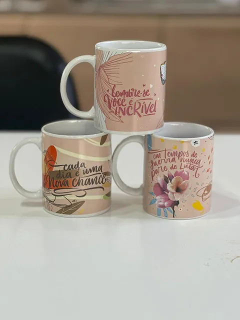 Canecas com frases motivacionais em tons rosados