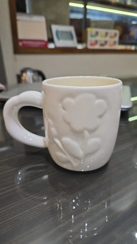 Caneca branca com flor em relevo