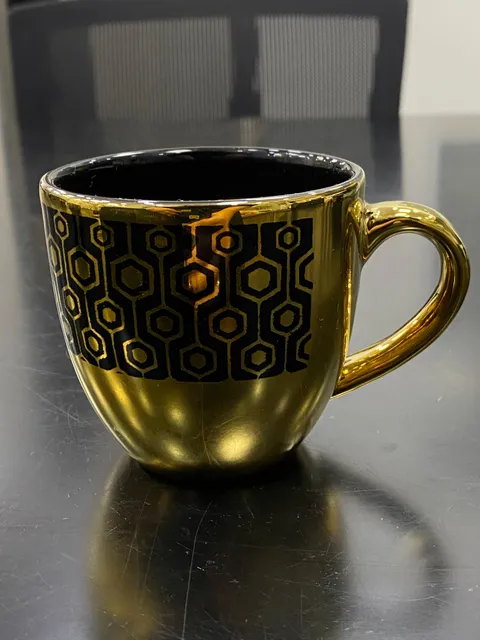 Xícara dourada com colmeia preta