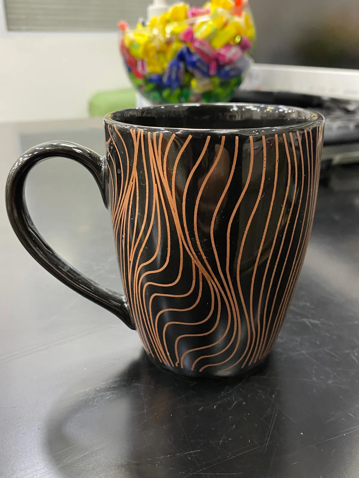 Caneca preta com linhas onduladas cobre