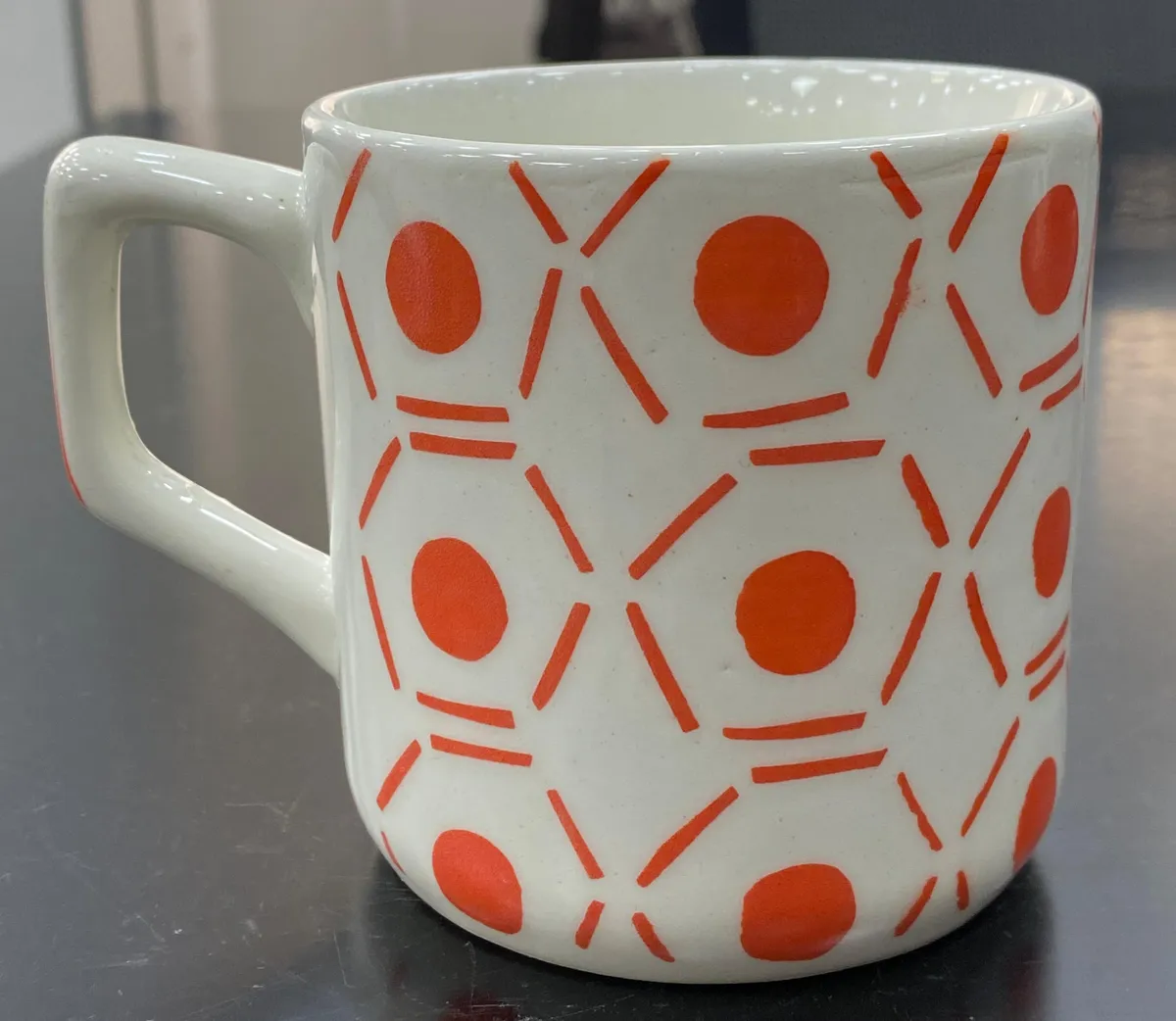 Caneca pintada à mão com círculos laranja e hexágonos