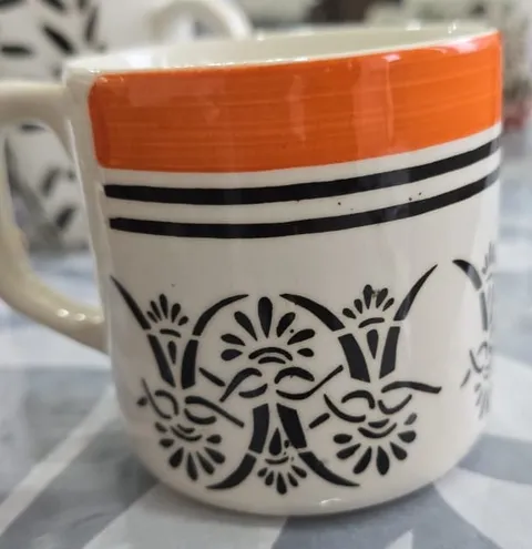 Caneca pintada à mão com faixa laranja e arabesco preto