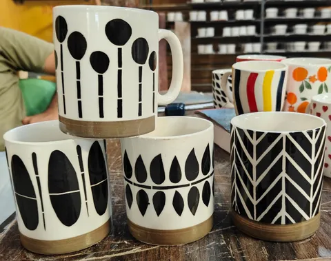 Sortido de canecas pintadas à mão preto e branco com base natural
