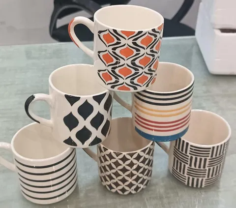 Sortido de xícaras pintadas à mão geométricas preto e laranja