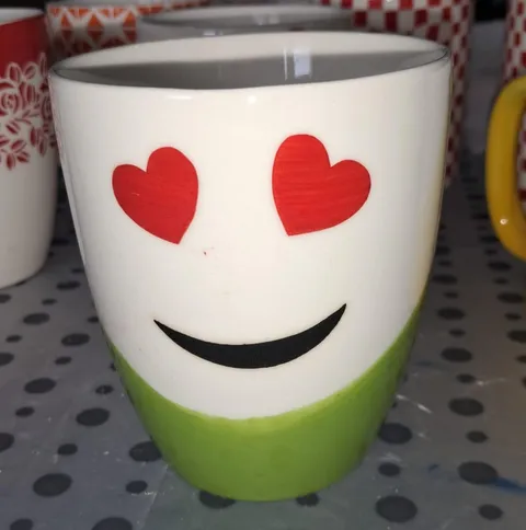 Caneca pintada à mão carinha com olhos de coração e base verde