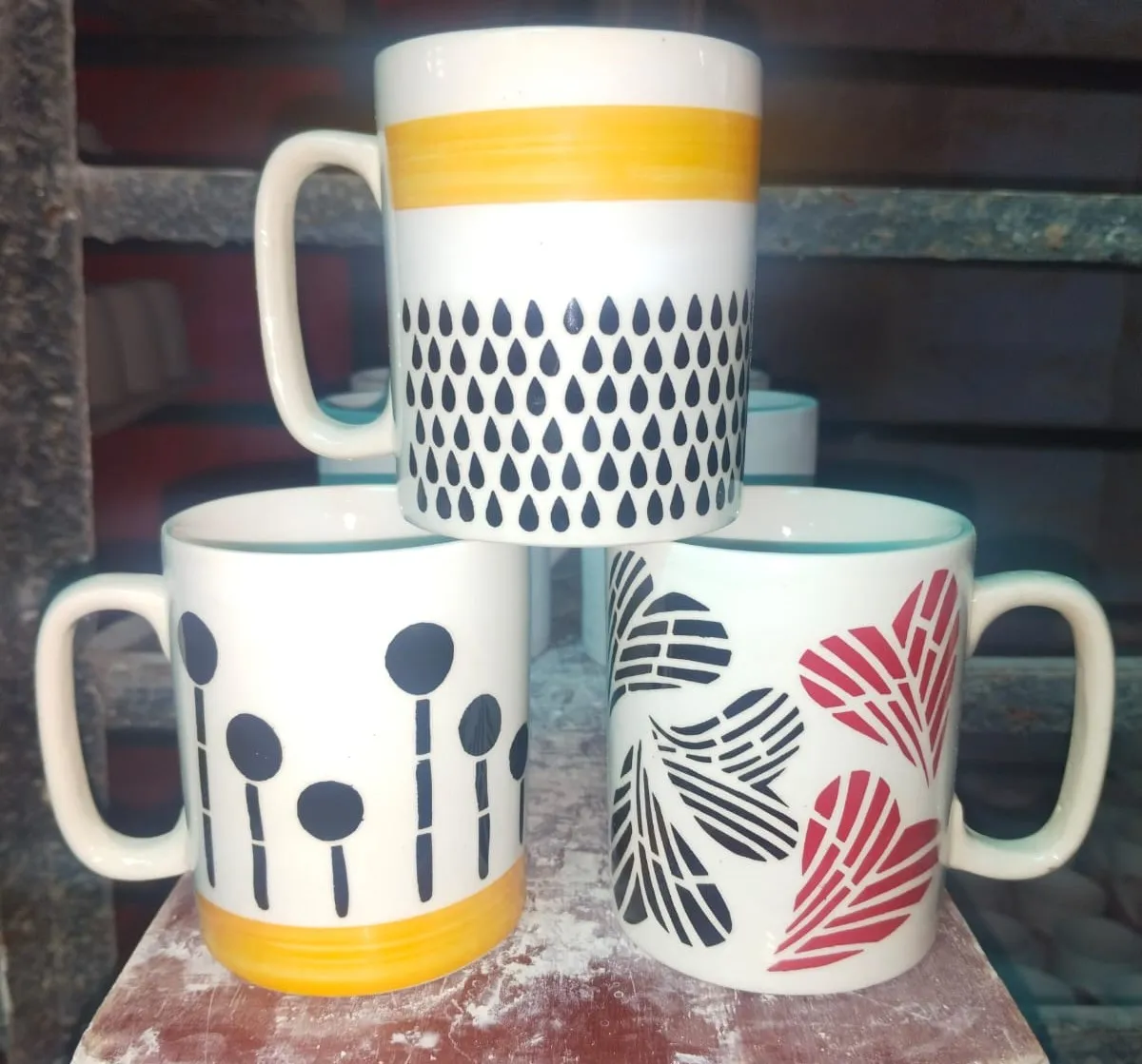 Trio de canecas pintadas à mão com faixa amarela e padrões pretos