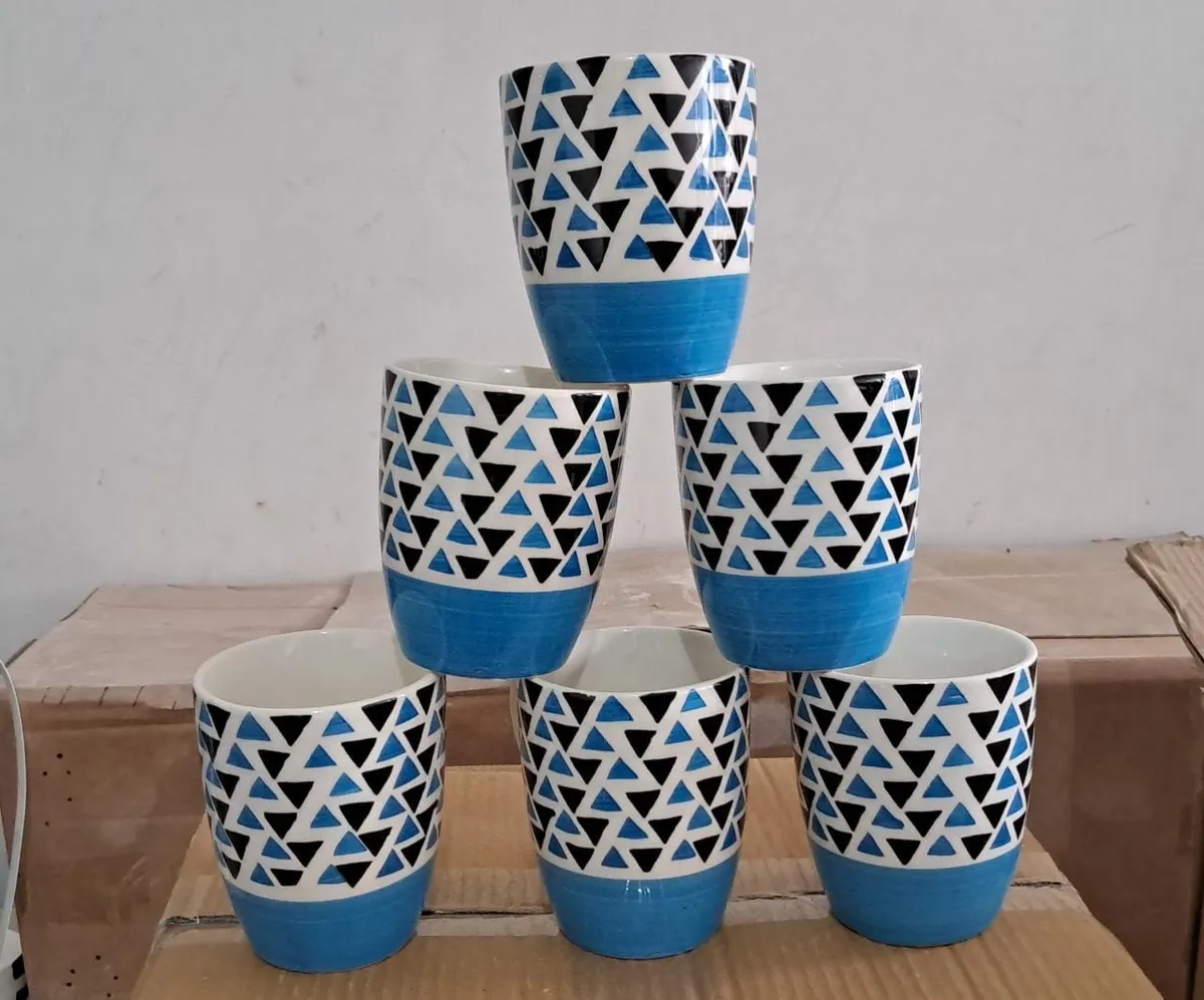 Xícara pintada à mão com triângulos e base azul