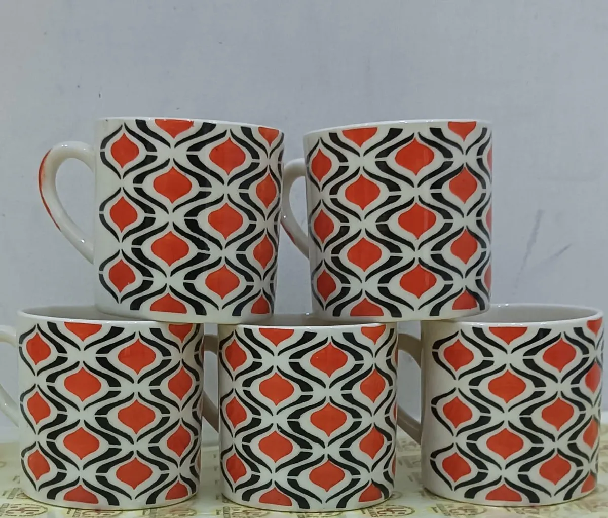 Caneca pintada à mão com ogivas laranja e pretas