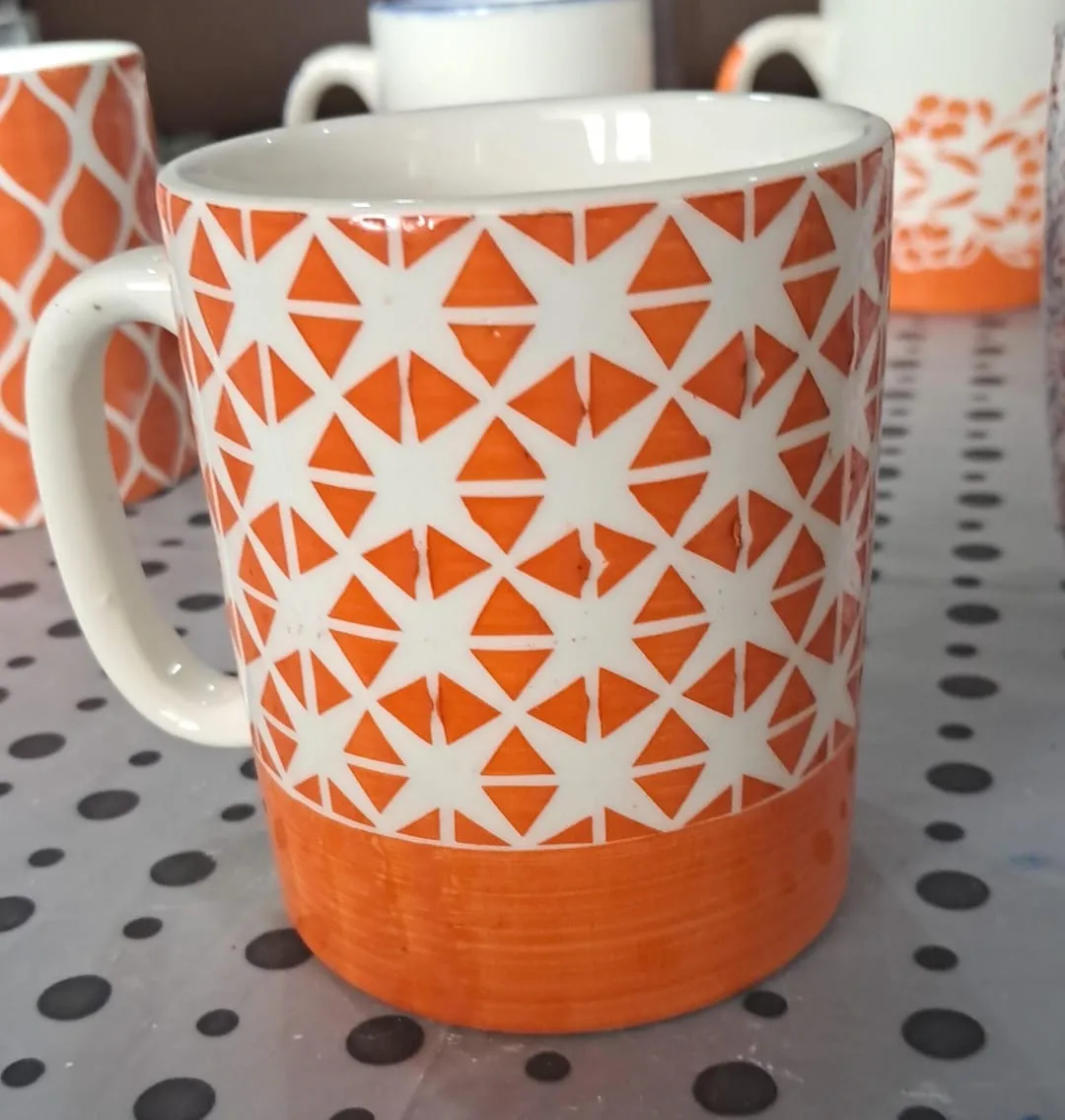 Caneca pintada à mão com estrelas laranja e base laranja
