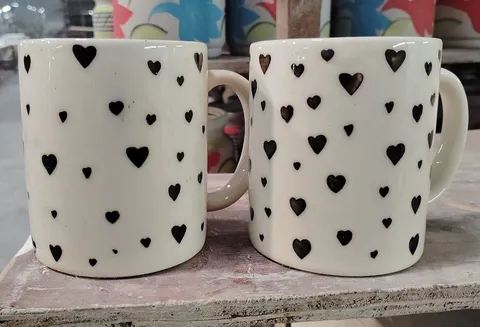 Caneca pintada à mão creme com corações pretos