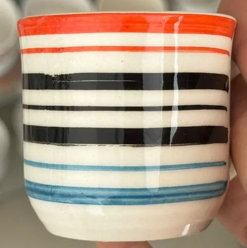 Caneca pintada à mão com listras laranja, pretas e azuis