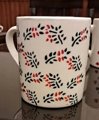 Caneca pintada à mão com ramos vermelhos e pretos