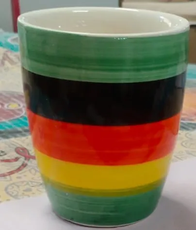 Caneca pintada à mão com listras verde, preta, vermelha e amarela