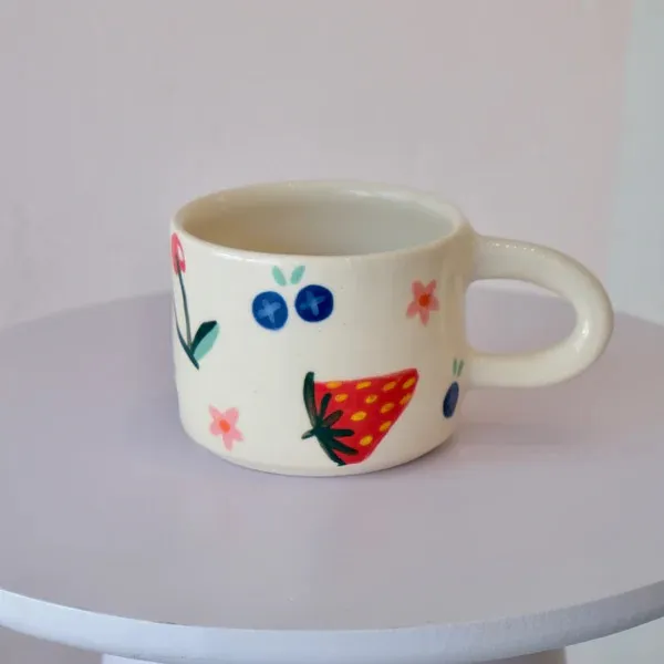 Xícara pintada à mão com morango e mirtilos