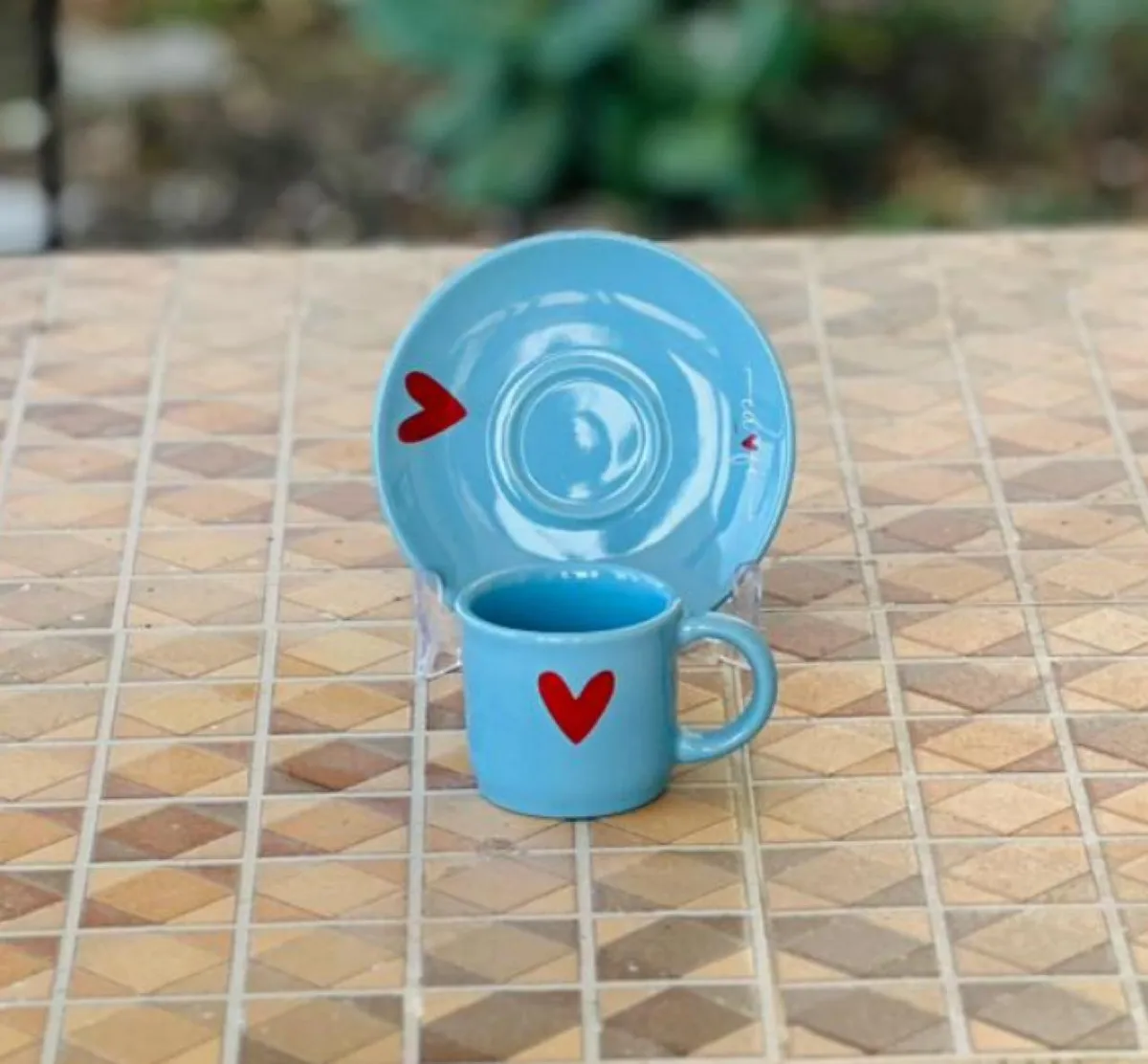 Xícara de café com pires azul e coração vermelho